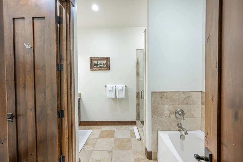 This en suite primary bathroom has a large glass walk in shower and oversized bathtub.