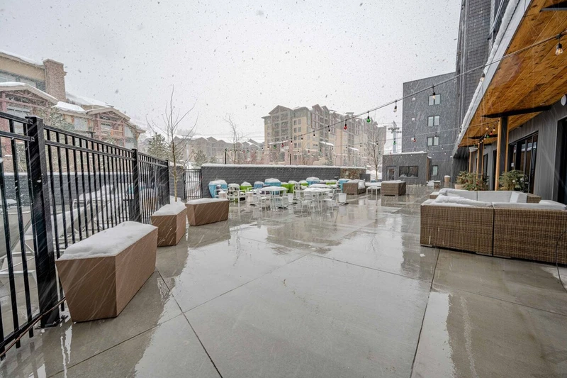 Take in the mountain views while relaxing in the modern outdoor furniture on the patio of the YotelPAD resort who offers ski valet and storage