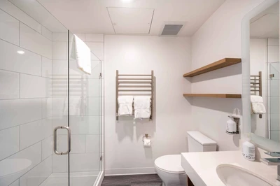 Modern and sleek private bathroom with heated towel rack and a walk in shower