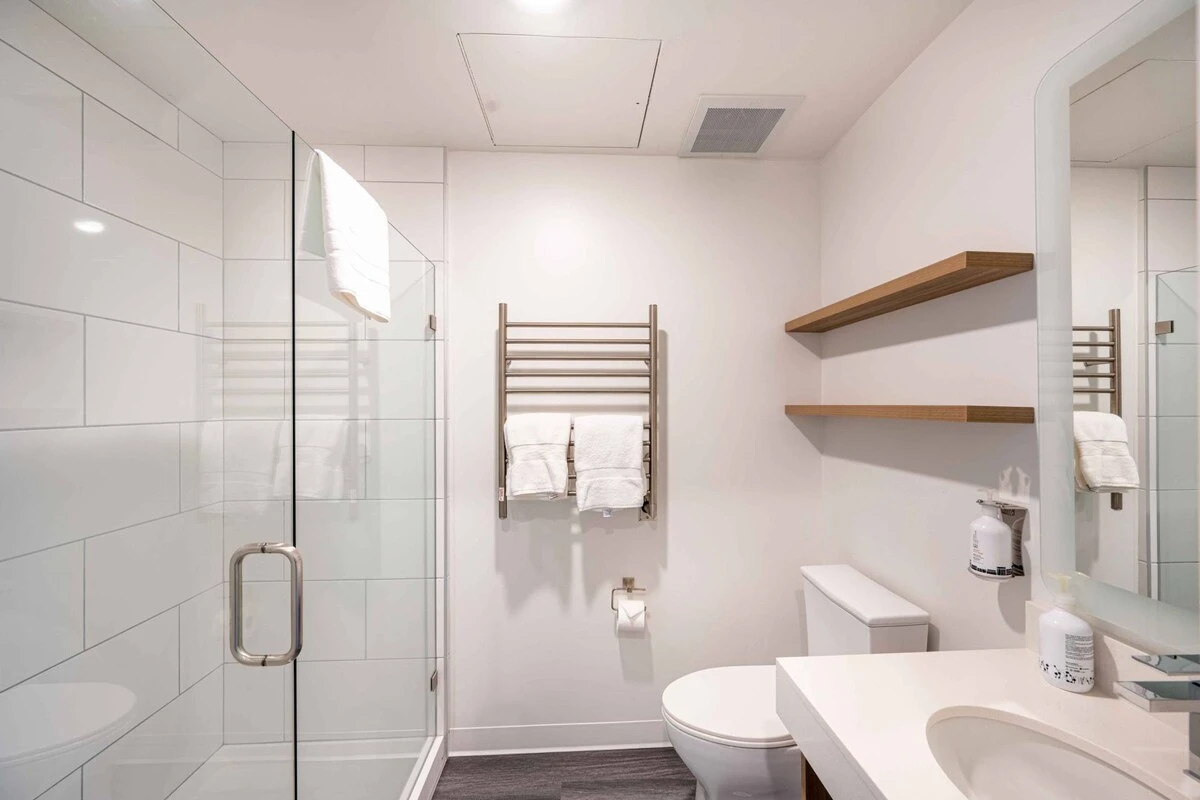 Modern and sleek private bathroom with heated towel rack and a walk in shower