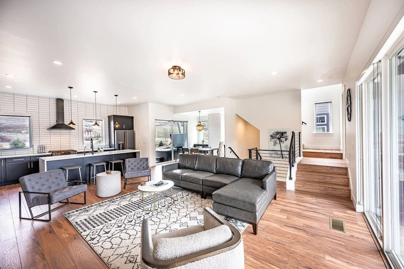 The welcoming open concept floor plan is filled with a refined combination of matte black, chic white and warm woods to create a chic interior