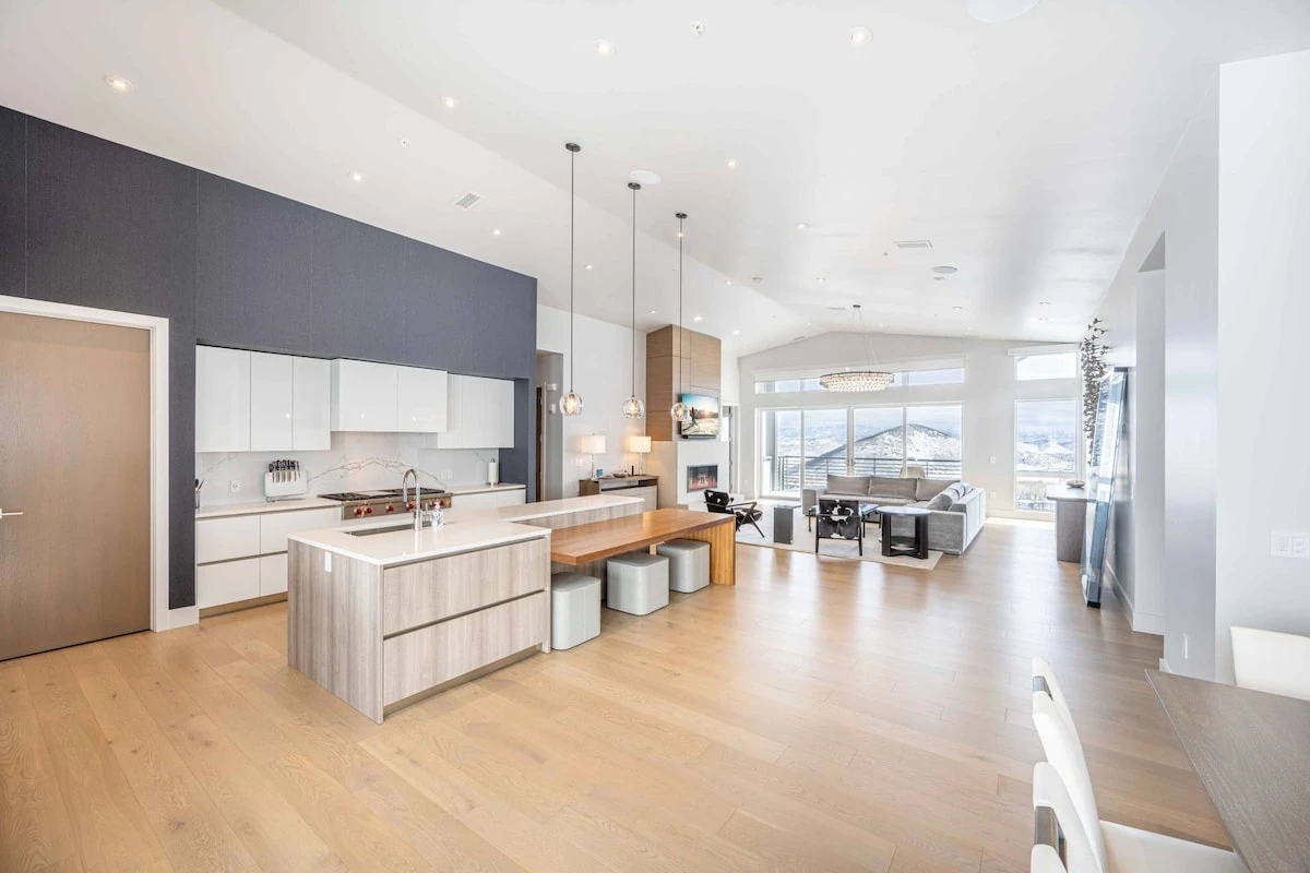 Open-concept kitchen and living area designed for group stays, featuring high-end appliances and mountain views.