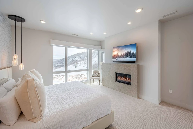 Primary suite with cal-king bed, mountain views, fireplace, and ensuite bath in this luxury Park City penthouse.
