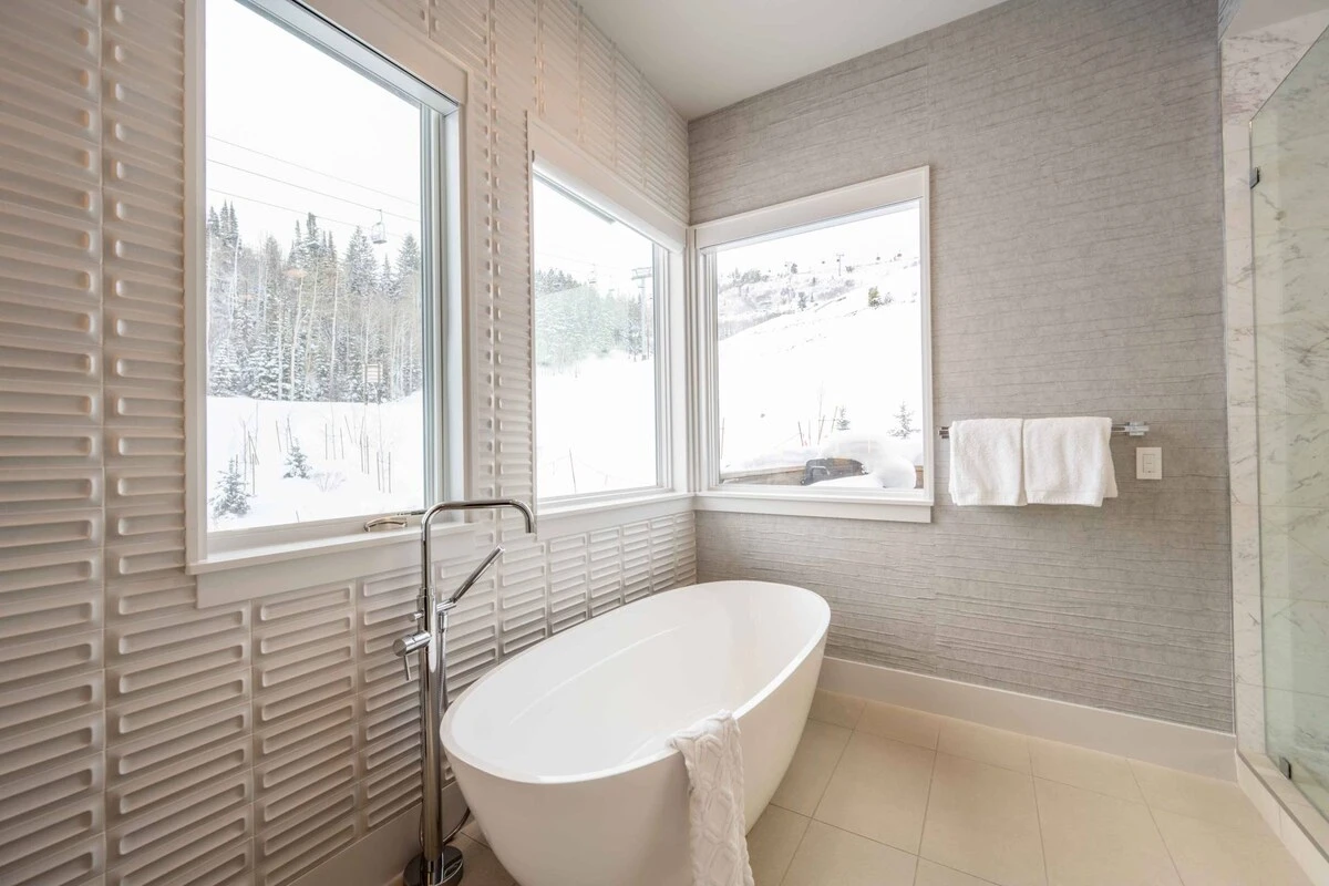 Primary bathroom with freestanding soaking tub and mountain views—perfect for relaxing after a full day skiing.