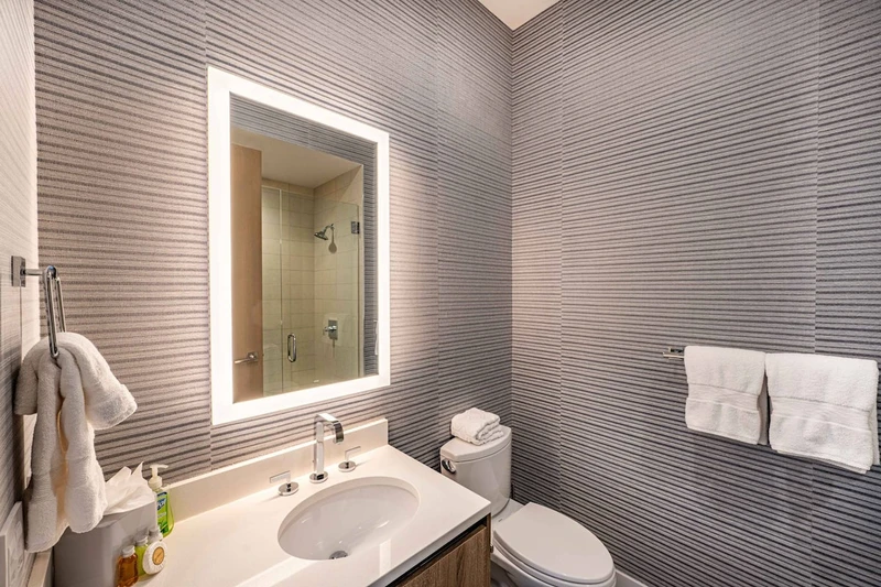 This is the En Suite Bathroom for the third guest Suite, featuring an LED Mirror, Quartz Vanity and Walk in Glass Shower.