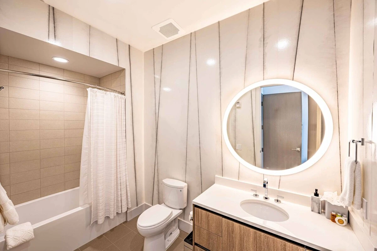 This is the bathroom adjacent to the bunk room suite. It features custom floor to ceiling marble tiled with thick black veins, white marble vanity wit