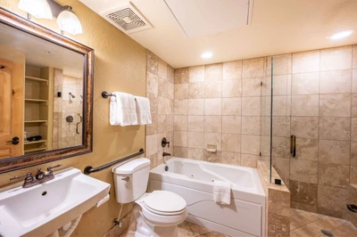 This is the spacious primary suite en suite bathroom with an oversized jetted tub, walk in glass shower, pedestal sink, professionally laundered  high