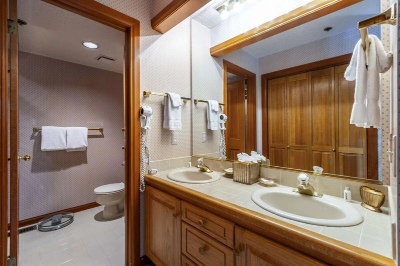 Lower Level Guest En Suite Bathroom Offers Twin Vanities and a Separate Toilet / Shower/ Bath Area
