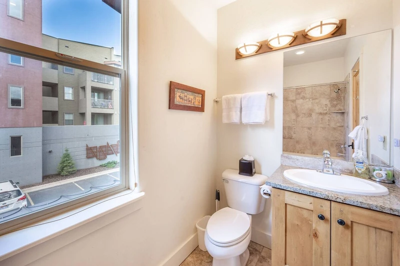 Located in the guest suite is the full guest bathroom - complete with privacy shades, granite vanity, stone tiled shower and bath