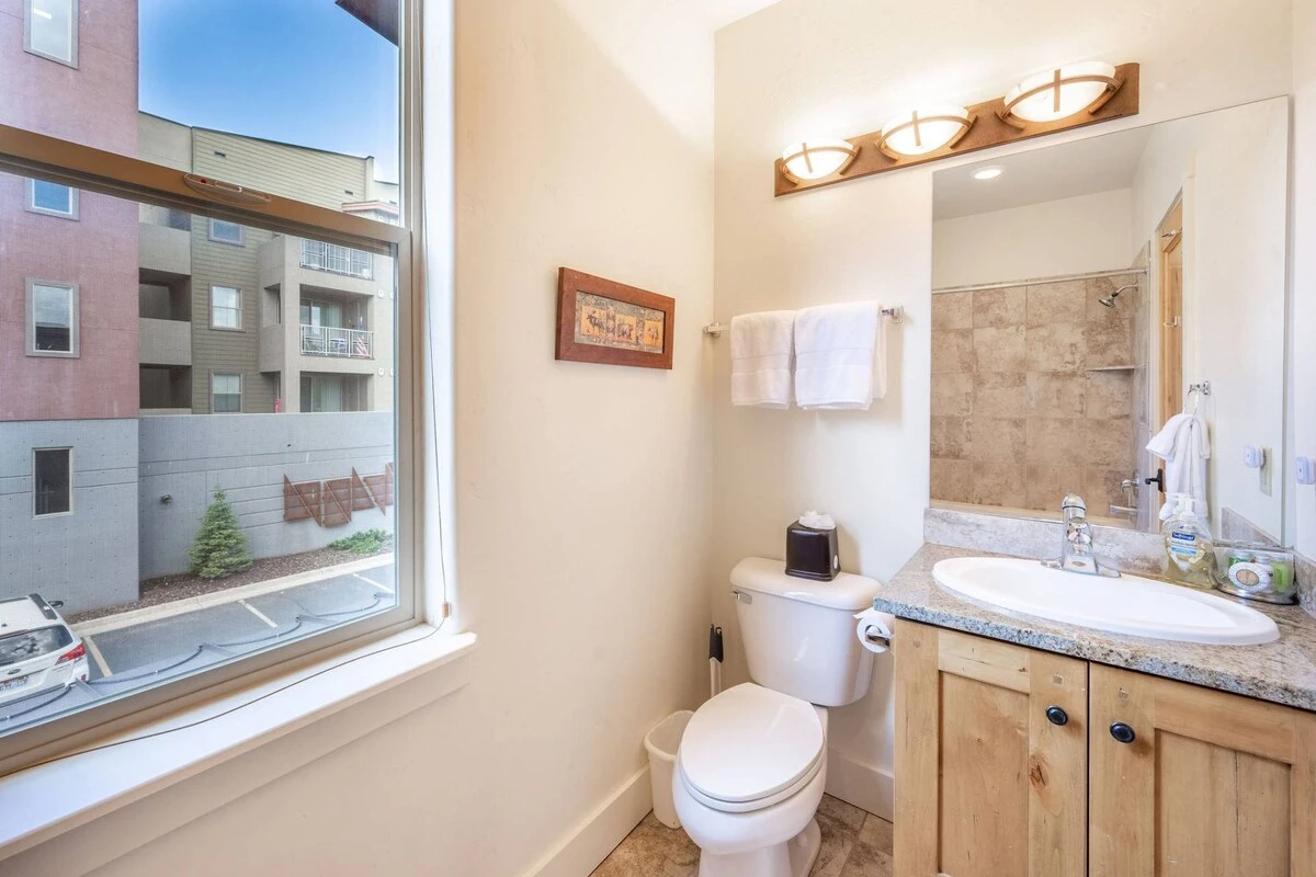 Located in the guest suite is the full guest bathroom - complete with privacy shades, granite vanity, stone tiled shower and bath
