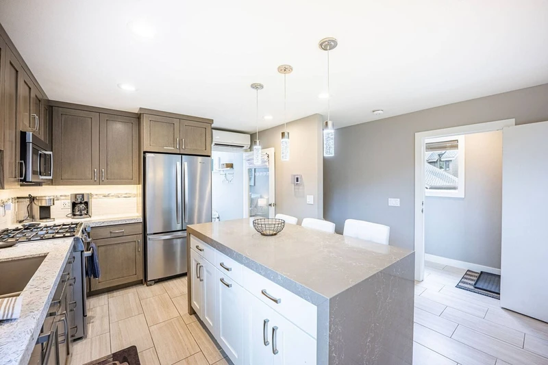 The newly renovated kitchen has stainless steel Bosch appliances including a gas range and french door fridge. The island features a custom waterfall