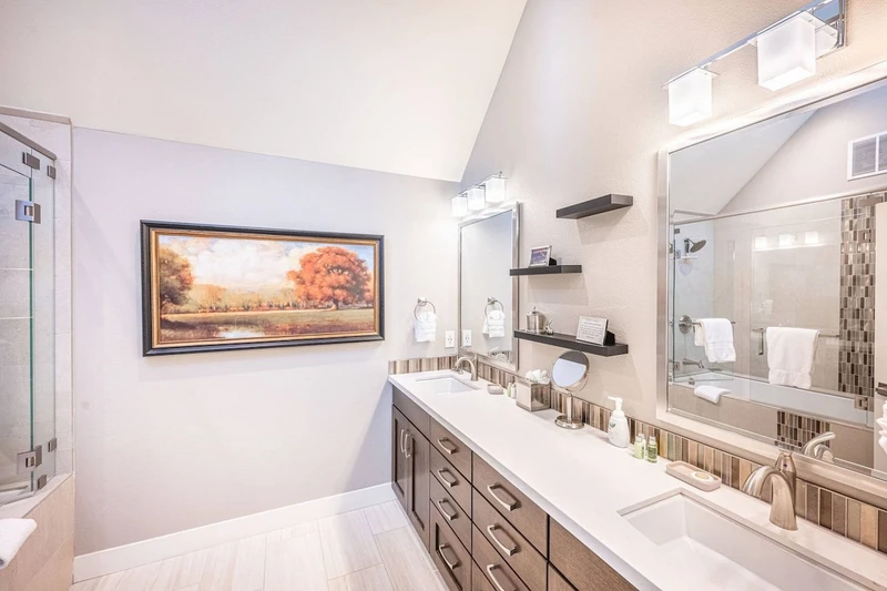 Elegant En Suite Primary Suite Bathroom Features Dual Vanities, Oversized Tub w Glass Shower and Vaulted Ceilings
