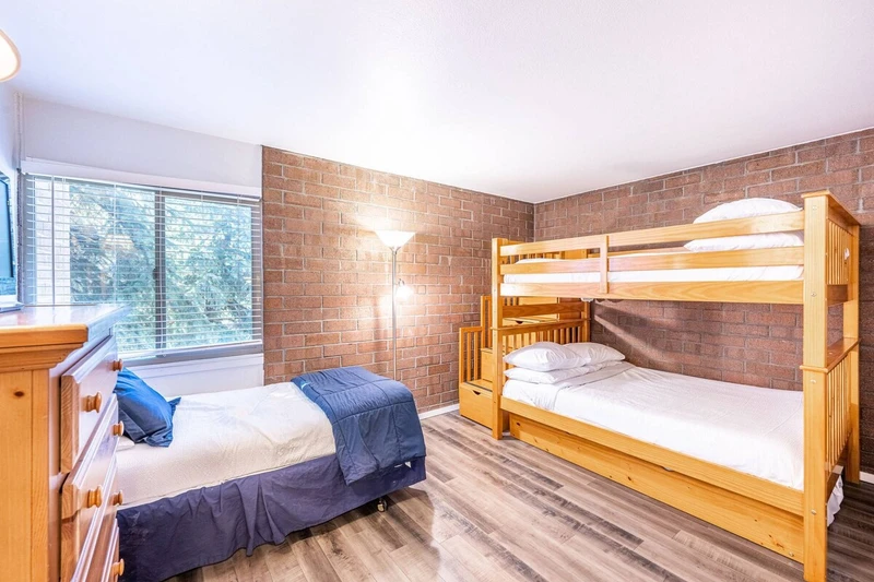 The second guest suite has beautiful exposed brick and beds for up to four guests. If you're planning a Park City family ski trip this room is great f