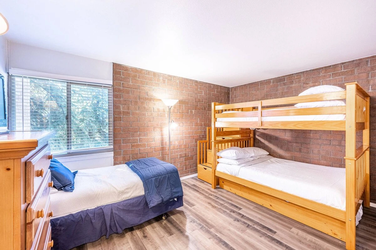 The second guest suite has beautiful exposed brick and beds for up to four guests. If you're planning a Park City family ski trip this room is great f