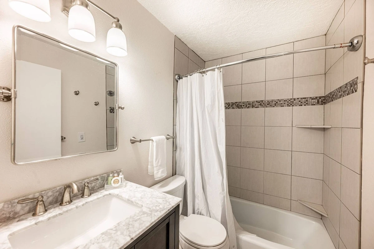 The primary suite en suite bathroom was recently updated with new designer tile in the shower/bath, new hardwood vanity with marble top and custom mir