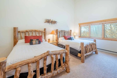 The spacious guest suite features two king size beds with high quality linens and bedding, flat-screen TV, hardwood dresser and windows with tree line