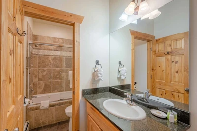 The guest bathroom is equipped with granite counters, stainless steel fixtures, Kohler sink and a fully enclosed tub and shower.