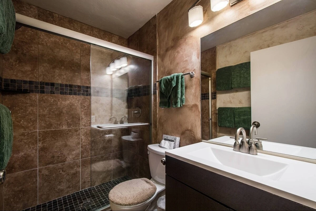 The second bathroom was also recently renovated and features large glass shower with two shower heads, new counter with vanity and modern lighting fix