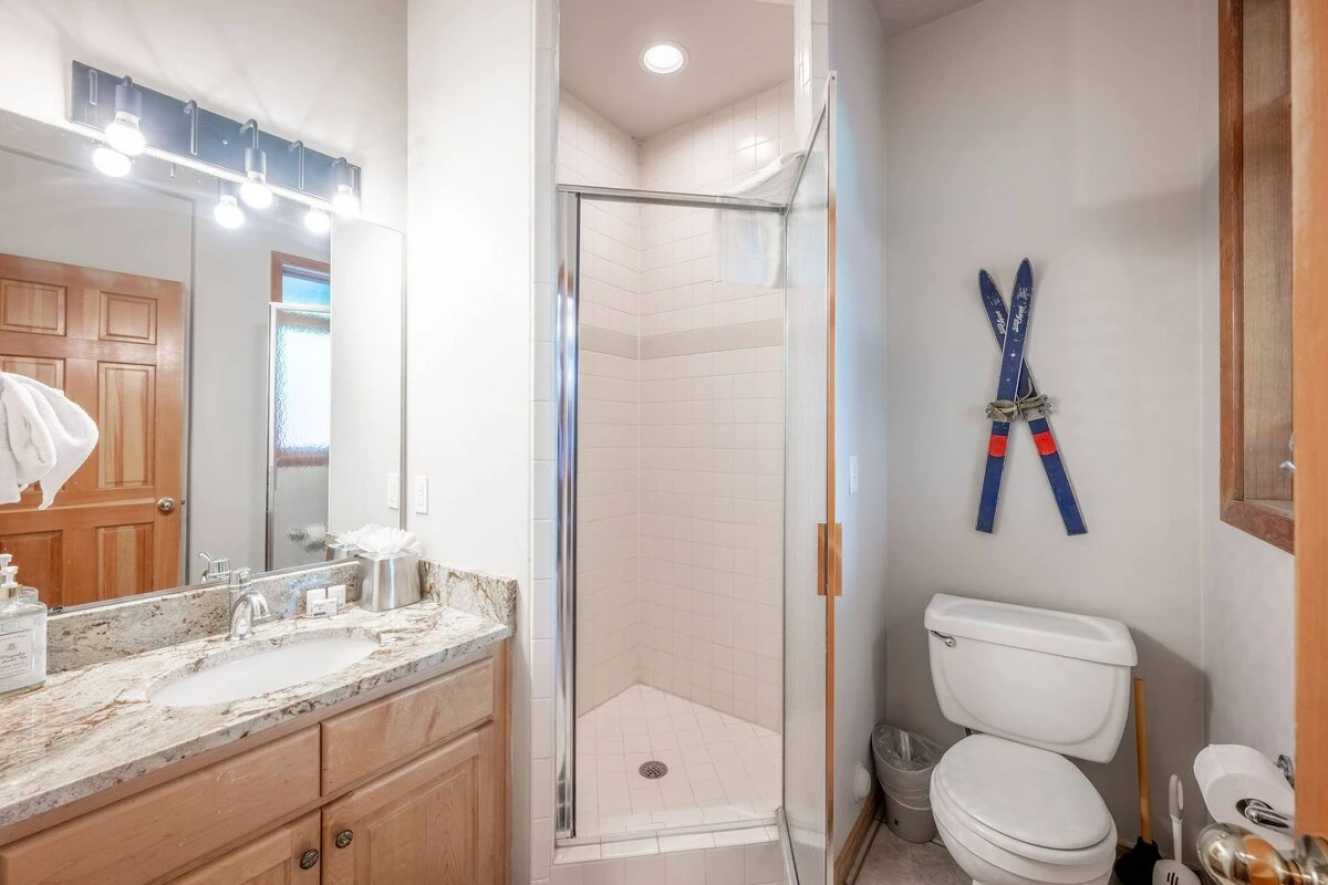 Welcome to our cozy home! The main floor bathroom boasts a stunning vanity with sleek stainless steel finishes and a spacious walk-in glass shower. Co
