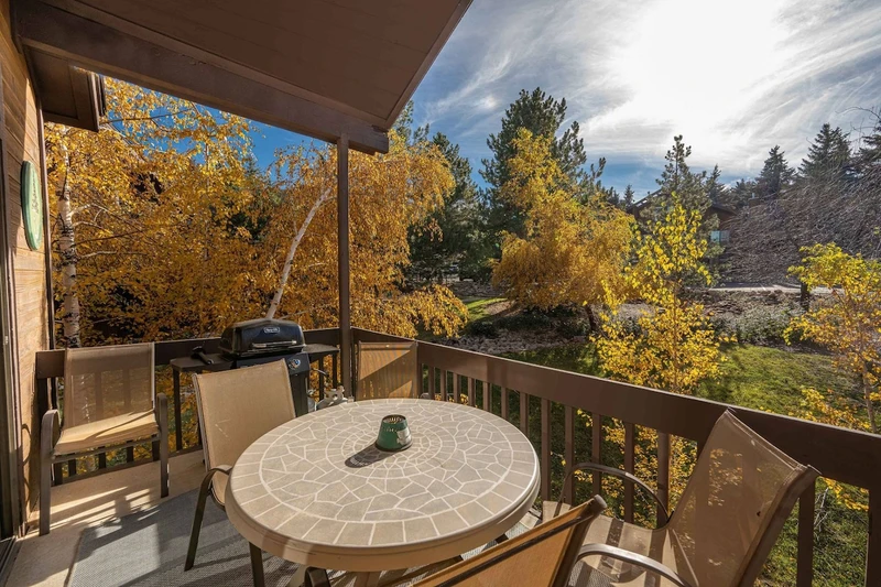 The private balcony is in a quiet setting and has dining furniture and an outdoor gas grill.
