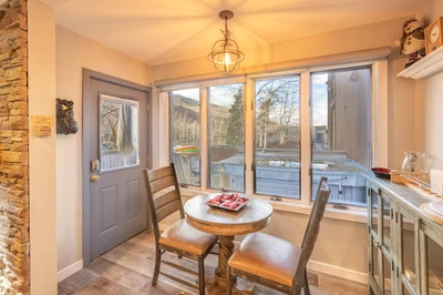 Adjacent to the living room is a fully updated traditional Park City dining room with large oversized windows featuring mountain views