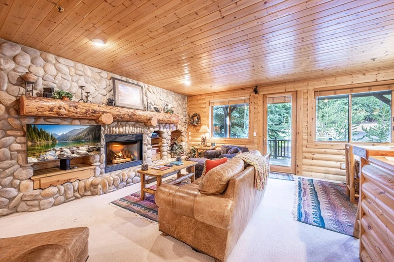 Spacious and inviting living area with Leather sofa (sleeper), comfortable chairs, river stone encased gas fireplace, HDTV with cable television and W