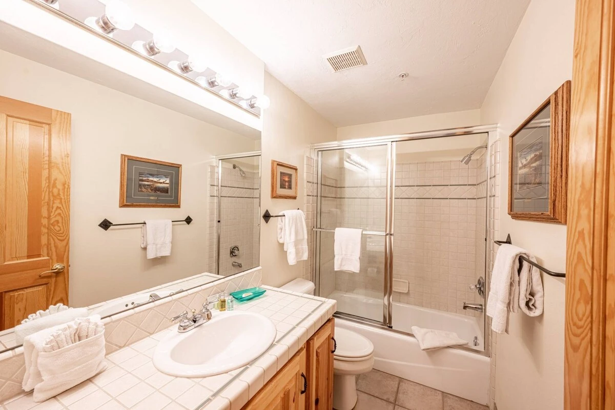 En Suite Bathroom with tiled vanity, tub, glass shower