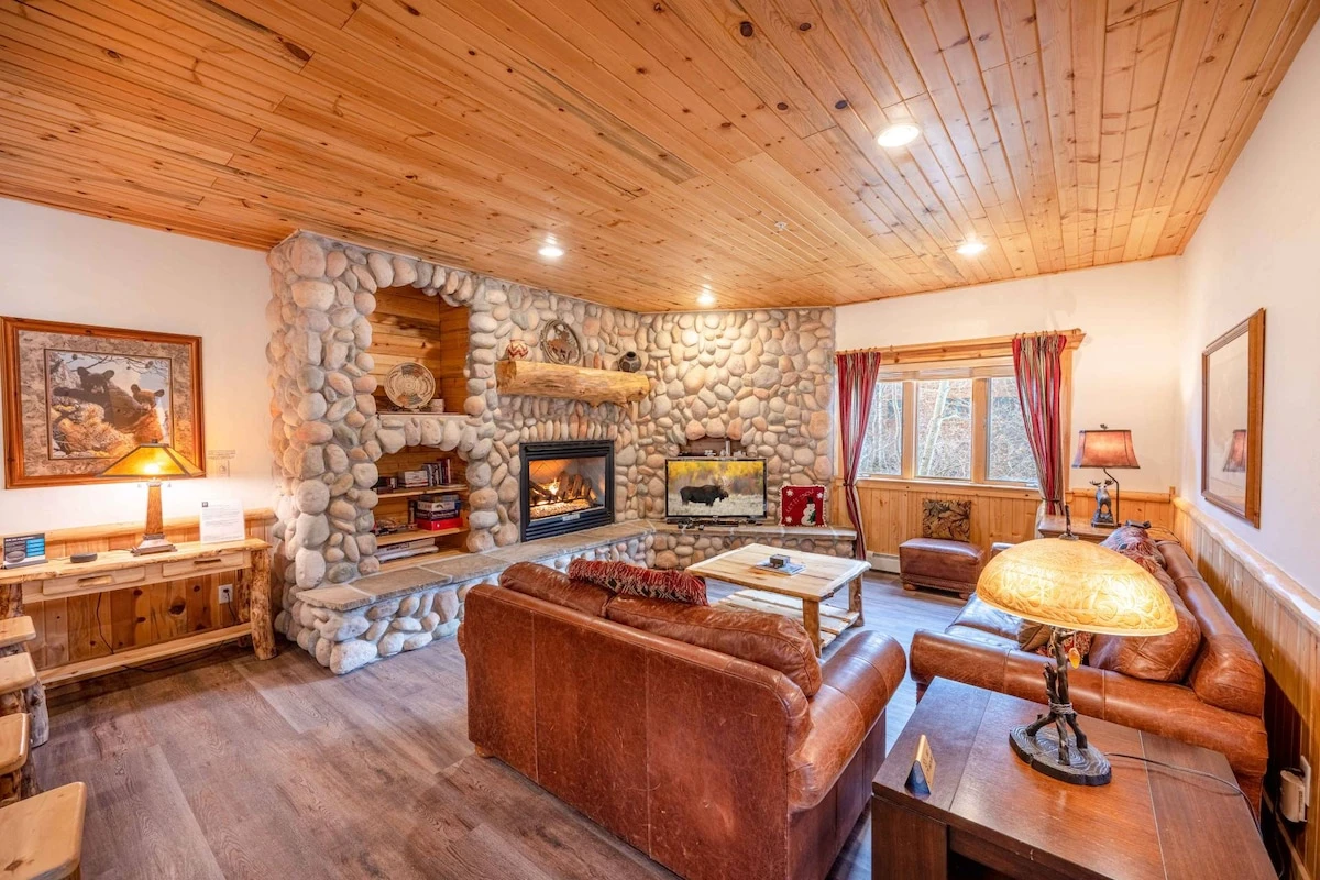 The bright and spacious living room has new hardwood flooring, 2 comfortable leather sofas, gas fireplace, board games and an HDTV