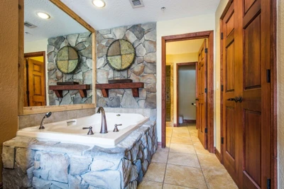 The primary suite has an oversized tub, the bathroom has a his and hers vanity, large tile countertop, large soaker tub with jets, walk-in shower and