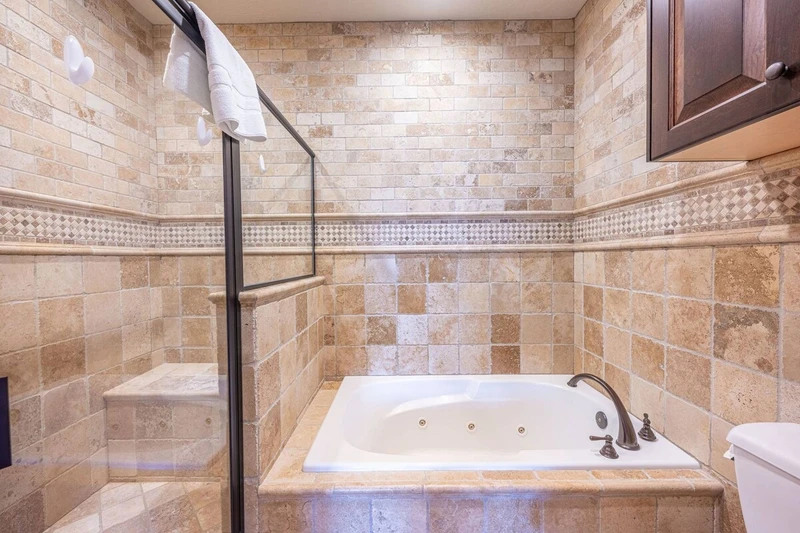 The primary suite has a jetted tub and a walk in glass enclosed rainfall shower!