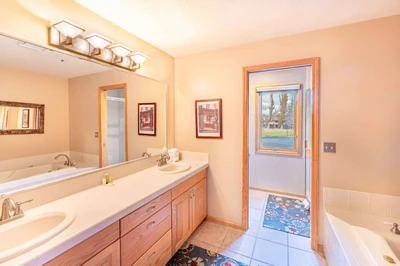 The primary en suite bathroom has dual vanities, an oversized jetted tub and a separate toilet/shower area