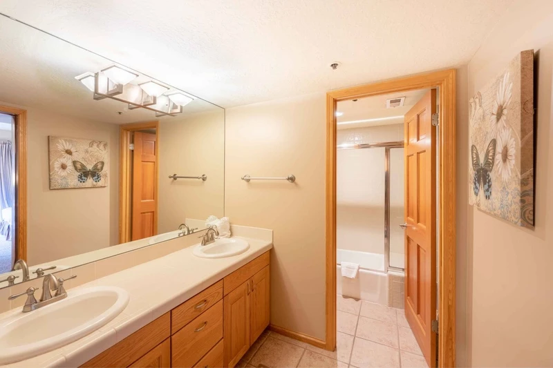 Guest bathroom with two vanities and privacy door to shower & bath