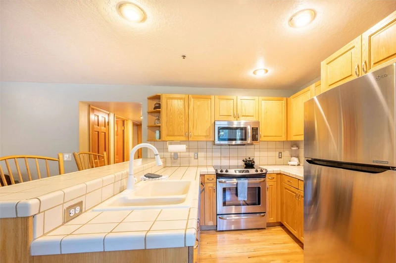 The cheerful kitchen was recently updated with new appliances and hardwood flooring. There is plenty of counter space for cooking.