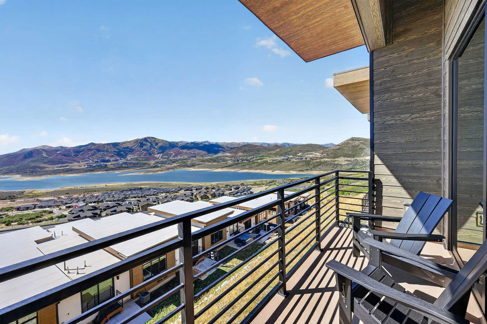 Deck off the living room with Adirondack chairs overlooking the reservoir