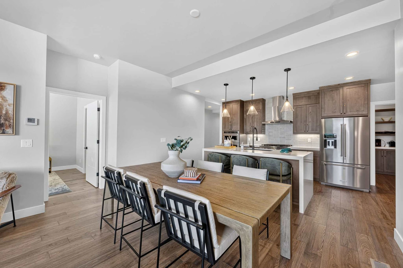 Open kitchen with quartz waterfall island, double ovens, and gas cooktop